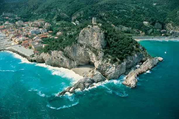 Promontorio roccioso che entra nel mare turchese, con una torre in cima