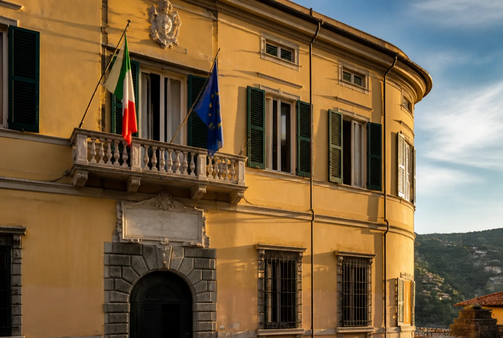 La facciata del municipio con le bandiere e il portone d'ingresso.